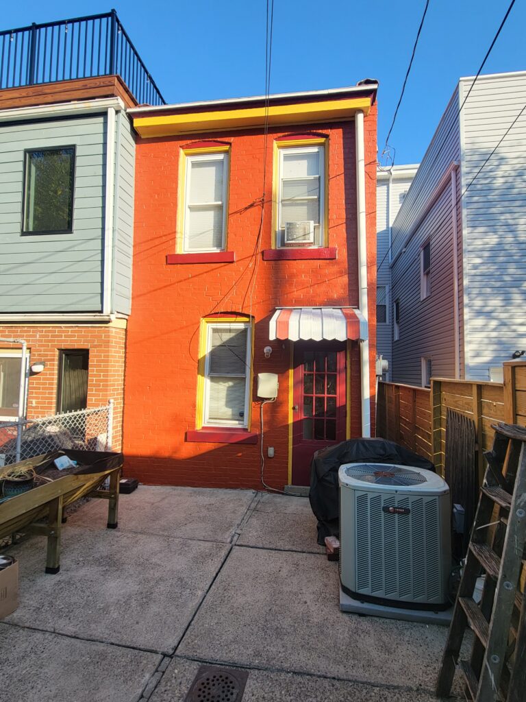 a view from the outside of newly painted property in vibrant orange color,